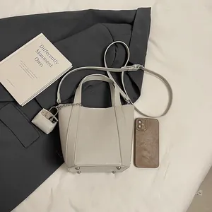 Elegante beige Eimertasche mit Tragegriffen und verstellbarem Crossbody-Schultergurt