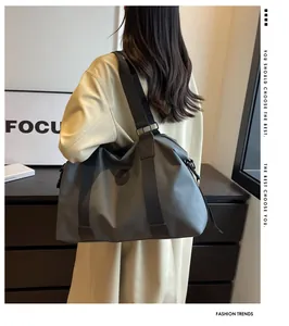 Bolso de viaje gris impermeable llevado por una modelo en una habitación moderna.