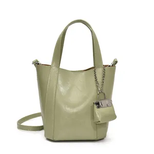 Elegante unifarbene Vintage-Eimertasche mit passendem Mini-Geldbörsen-Anhänger für den Alltag