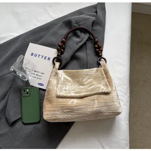 Primer plano de un bolso vintage de terciopelo floral con asa de cuentas de madera