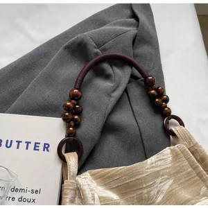 Detalle del asa de cuentas vintage y el suave terciopelo de un bolso elegante.