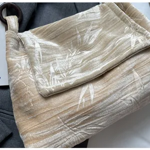 Detalle de bolso de terciopelo de estilo chino moderno con patrón de hojas de bambú champán