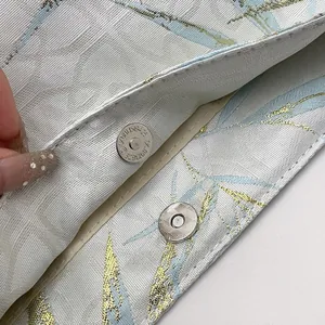 Primo piano della chiusura magnetica e della trama del tessuto di una borsa floreale