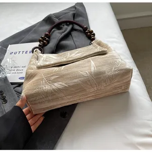 Vista detallada de un bolso chino retro con cuentas de madera y estampado de hojas