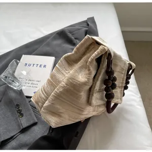 Detalle del bolso de terciopelo de estilo neo-chino con asas de cuentas de madera