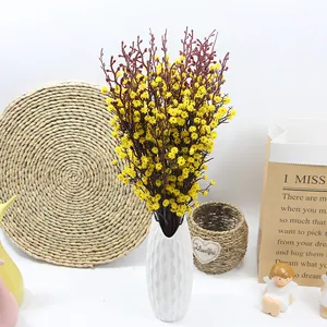 Vivace bouquet di gipsofila artificiale gialla in un moderno vaso di ceramica bianca