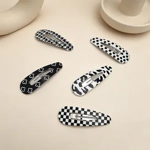 Close-up of five UV printed BB hair clips with varied black and white chic patterns