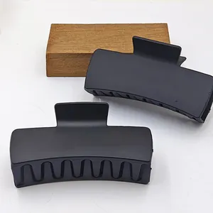Close-up macro view of 11cm matte black square hair claw clips with a solid design