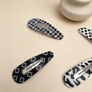 Detail shot of UV printed teardrop hair clips in classic black and white patterns.