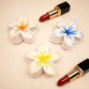 Set of three colorful frangipani flower hair claws, perfect for summer beach styling.