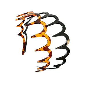 Detail view of wavy long-toothed headbands in tortoiseshell and black finish.