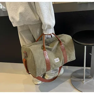 Große olivgrüne Canvas-Reisetasche, von einer Person getragen in lässiger Umgebung