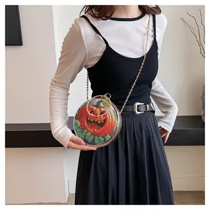 Close-up of quirky transparent round pumpkin handbag with gold chain strap on model