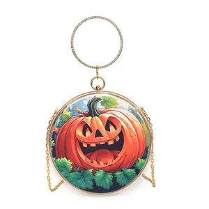 Detailed view of a round pumpkin handbag with rhinestone handle and gold chain.