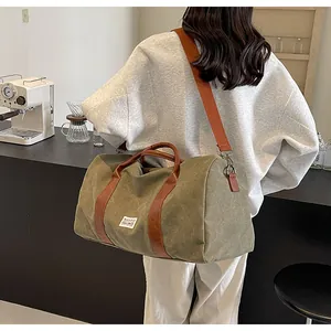 Große olivgrüne Reisetasche aus Segeltuch mit braunen Lederriemen für Damen-Wochenendausflüge.