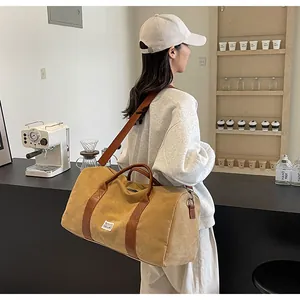 Asiatisches Model trägt eine khakifarbene Reisetasche aus Segeltuch in einem Café
