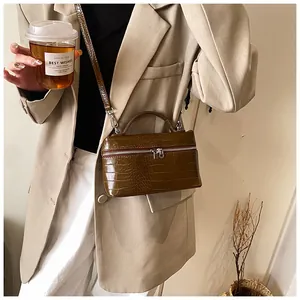 Stylish dark green crocodile embossed box handbag shown in a chic lifestyle setting