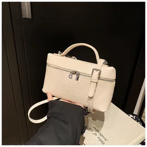 Detailed view of cream crocodile-embossed box handbag with silver hardware