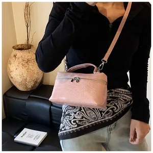 Elegant pink crocodile texture box bag featured with a shoulder strap on a model.