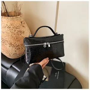 Detailed view of black crocodile pattern box bag with silver hardware and top handle