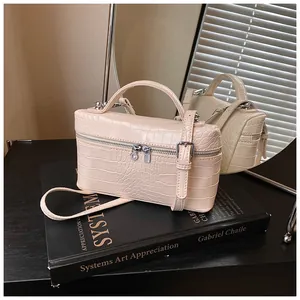Close-up of a cream crocodile pattern box handbag with silver hardware and a top handle
