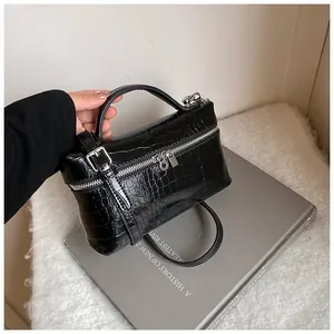 Close-up of black crocodile embossed leather box bag with silver hardware detail