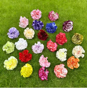 Detailed view of various colorful artificial carnation flower heads on green grass
