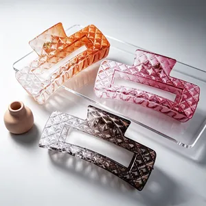 Macro detail of large square hair claw clips with gradient colors and quilted texture