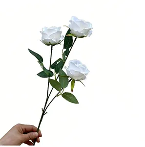 Vista detallada de rosas de perlas blancas artificiales de tres cabezas con hojas verdes