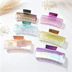 Close-up detail of gradient large hair claw clips in various elegant pearlescent colors