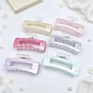 Detail showing six colorful marbled acrylic hair claw clips with elegant hollow design