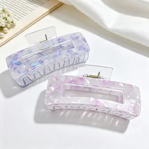 Close-up of elegant acrylic hair claw clips with colorful shell patterns and square design.