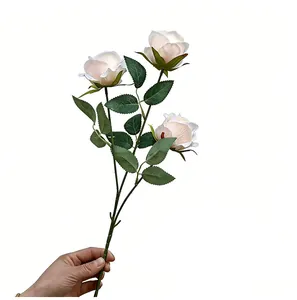 Detalle de cerca de rosas artificiales de color blanco perla de tres cabezas para boda