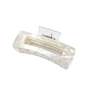 Close-up of a large ivory marbled acrylic hair claw clip for elegant hair styling