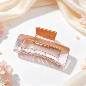 Close-up of an iridescent UV electroplated square hair claw clip on soft silk