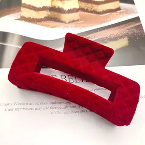Gedetailleerd macro-aanzicht van wijnrode haarklem met elegante gewatteerde textuur