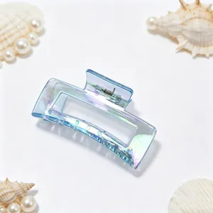 Macro view of iridescent blue electroplated hair claw clip with seashell decorations.