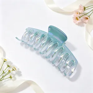 Close-up of iridescent blue-green gradient shark claw clip with UV plated finish