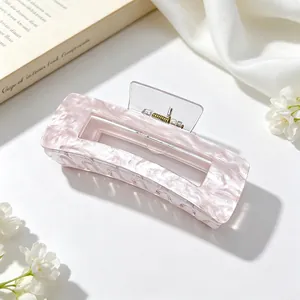 Detailed view of a large pink marble textured acrylic hair claw clip for elegant styling