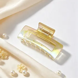 Detailed view of iridescent UV-plated square hair claw clip set on soft silk fabric.
