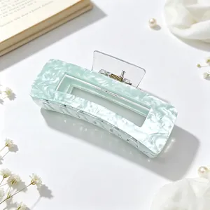 Macro view of mint green marbled acrylic hair claw clip with elegant texture and design