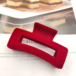 Detailopname van de zachte, fluweelachtige textuur van de wijnrode gevlokte haarklem.