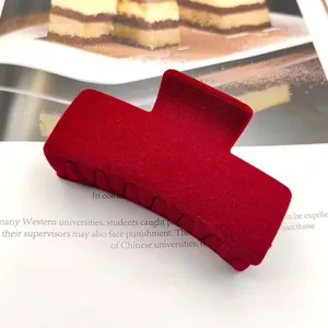 Detailopname van een wijnrode haarklem met flocking en een zachte fluwelen textuur
