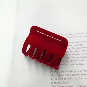 Detailopname van een elegante wijnrode geflockte haarklem op tijdschrift