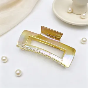 Detail of a large rectangular hair claw clip with a shimmering UV AB gradient finish.
