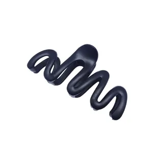 Close-up detail view of a minimalist matte black wave-shaped hair claw clip for women.