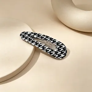 Detailed macro view of black and white houndstooth teardrop hollow hair clip