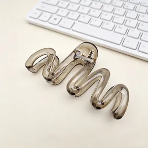 Macro detail of the elegant wave-shaped translucent grey PC hair claw clip design