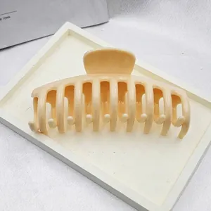 Detail view of a large cream dragon bone hair claw clip for women's styling