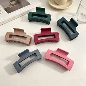 Pinces à cheveux rectangulaires mates de différentes couleurs sur une table blanche pure